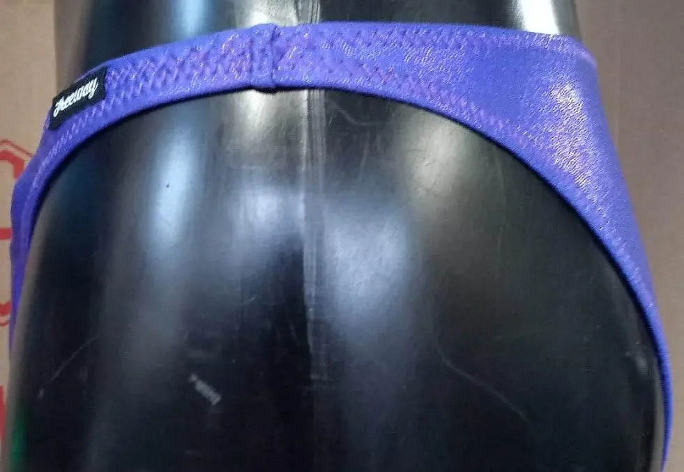 Thefreeway DN109 violet laminated competition bodybuilding posing trunks, close-up side detail showing the narrow waistband and logo