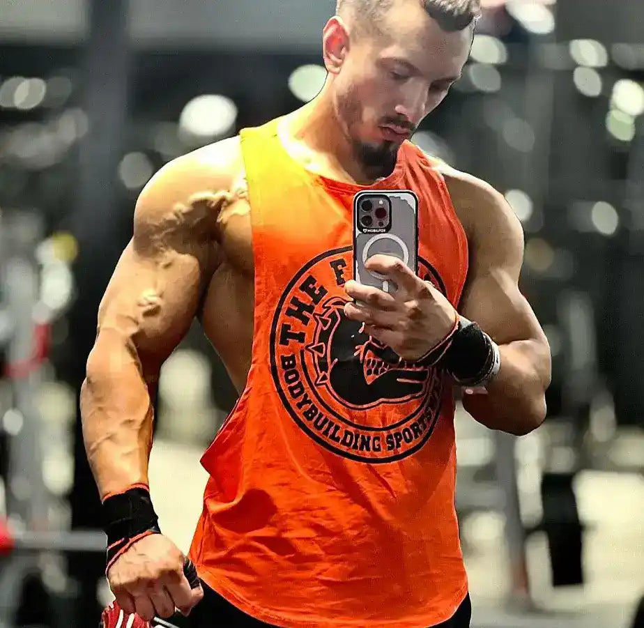 Muskelbepackter Mann im orangefarbenen Tanktop.