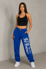 Unisex blue bodybuilding training pants by Thefreeway Sportswear worn by a model in a front pose with white leg logo