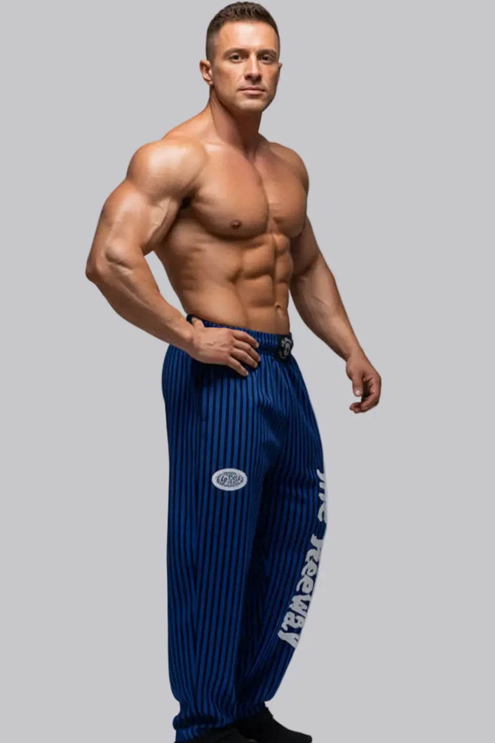 Thefreeway Art.253 unisex bodybuilding training pants in royal blue and black stripes worn by a male bodybuilder in a side pose