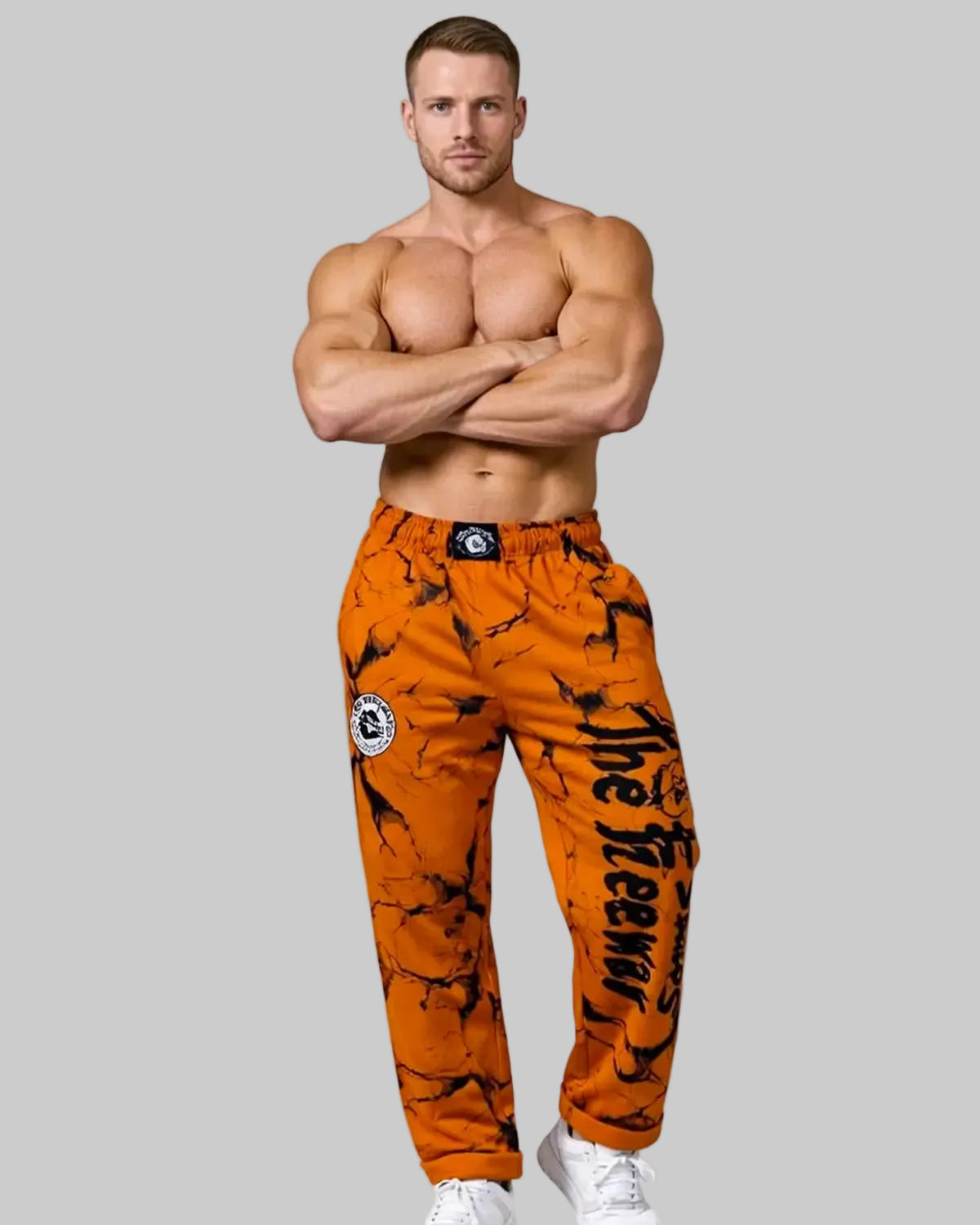 Unisex mustard marbled bodybuilding training pants by Thefreeway Sportswear worn by a bodybuilder with crossed arms, front view