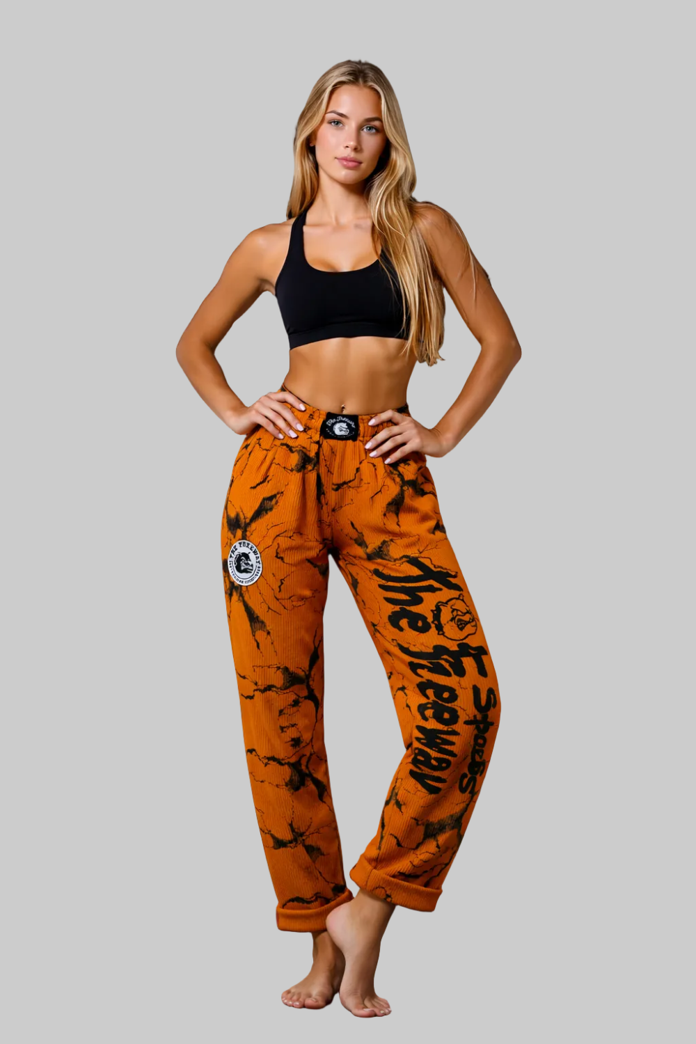 Unisex mustard marbled bodybuilding training pants by Thefreeway Sportswear worn by a female model in a front pose with black leg logo