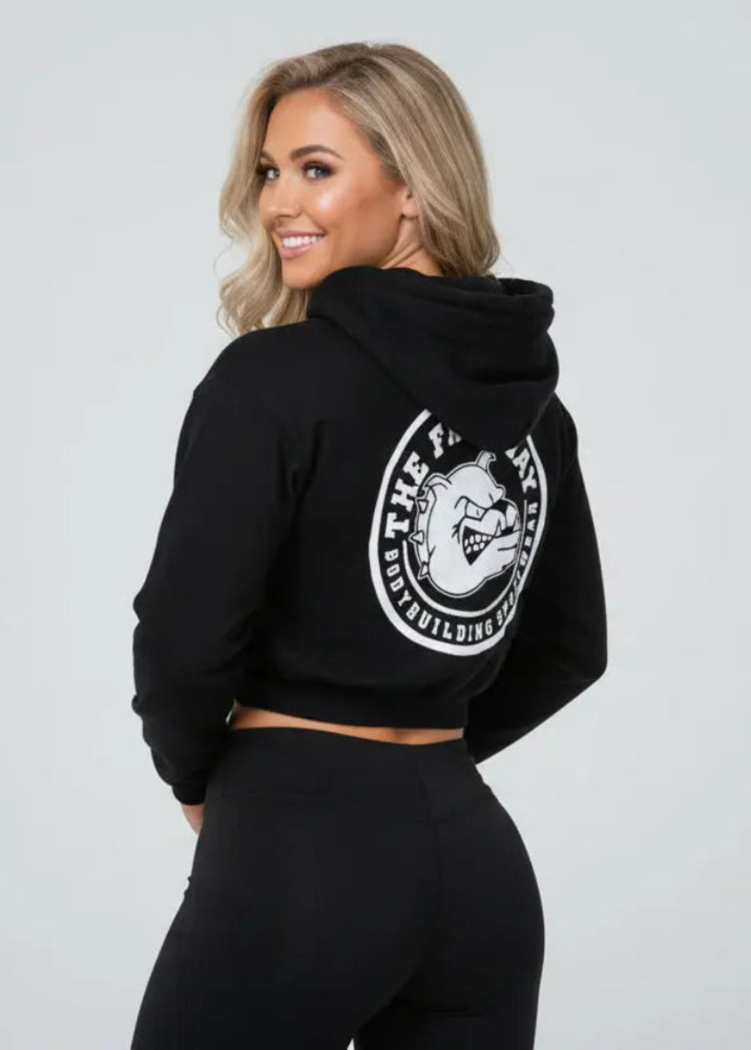 Thefreeway Art.7870 women's black training suit hooded jacket worn by a female model, three-quarter back view showing the large rear logo