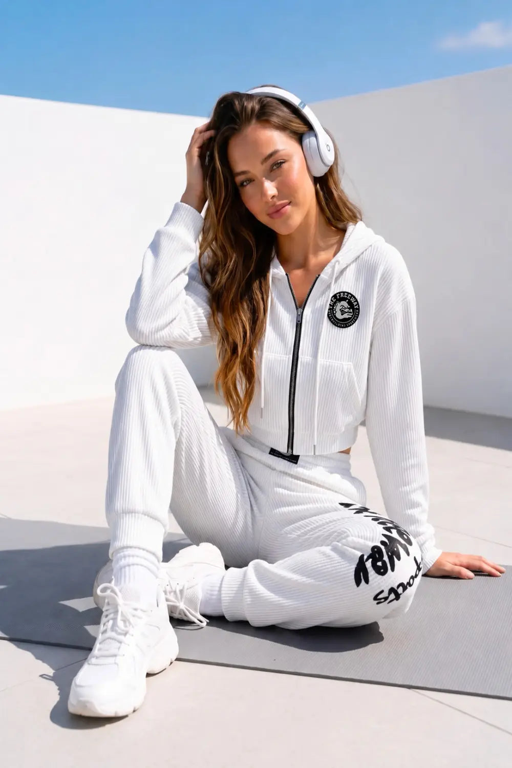 Thefreeway Art.7870 women's white training suit worn by a female model seated outdoors, lifestyle view